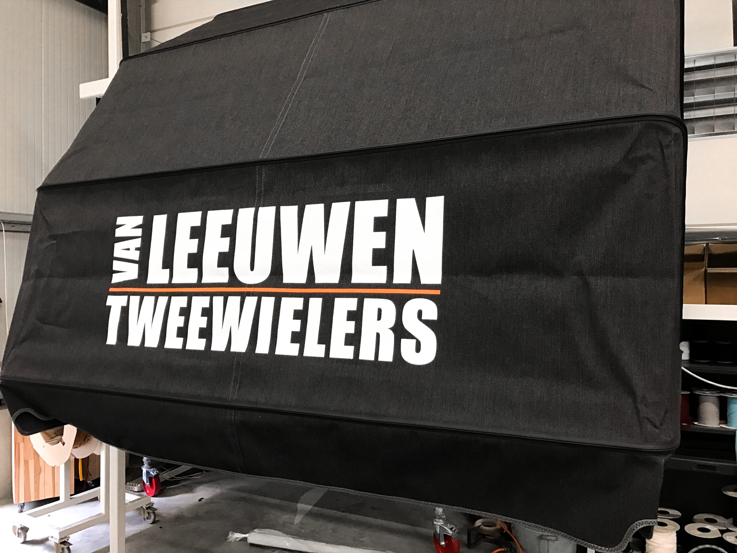Zwarte zonneluifel met bedrukt logo van Van Leeuwen Tweewielers